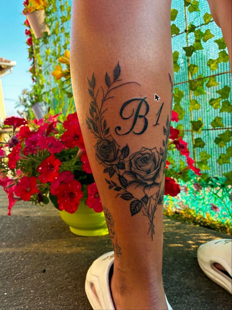 Rózsás tetoválás írott betűs monogrammal egy vádlin